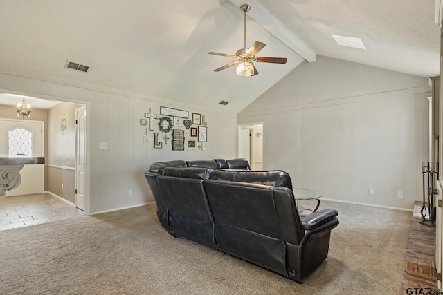 carpeted living room featuring ceiling fan with notable chandelier and vaulted ceiling with skylight