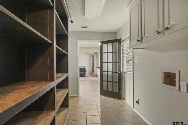 interior space with light tile patterned flooring and a textured ceiling