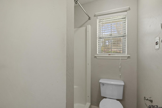 bathroom with a healthy amount of sunlight, toilet, and a shower