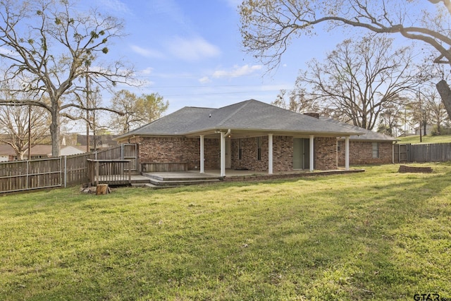 rear view of property featuring a yard and a deck