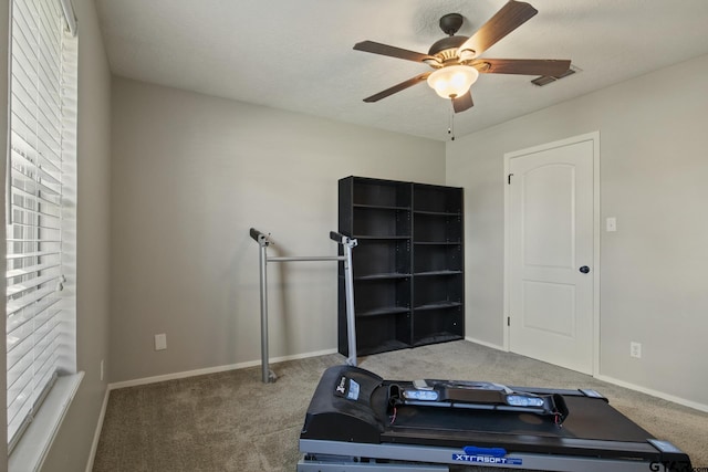 exercise room featuring ceiling fan and carpet flooring