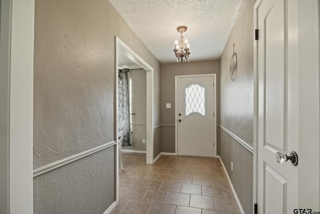 entryway featuring an inviting chandelier and a textured ceiling