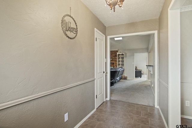 corridor featuring carpet floors and a textured ceiling