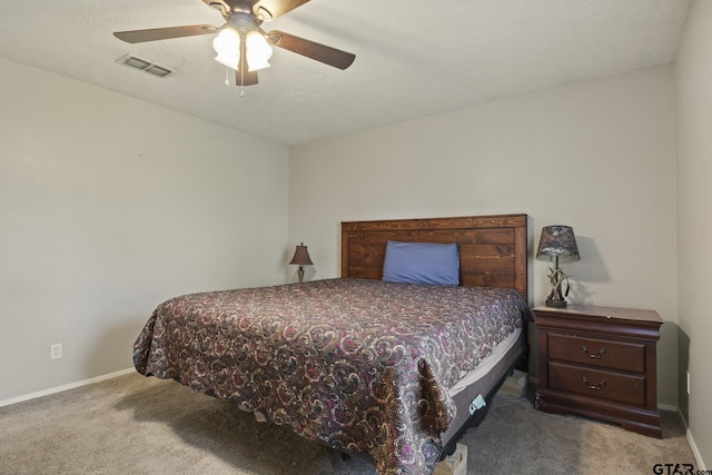 carpeted bedroom featuring ceiling fan and a textured ceiling