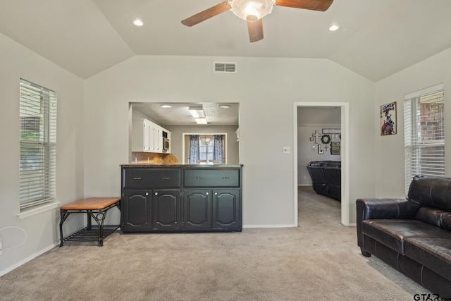 carpeted living room with lofted ceiling and ceiling fan