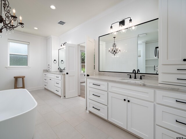 1555 Maple Crk, Tyler, TX 75703 - bathroom featuring a chandelier, healthy amount of natural light, two vanities, crown molding, and a freestanding tub
