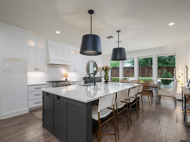 1555 Maple Crk, Tyler, TX 75703 - kitchen with premium range hood, white cabinetry, a spacious island, dark wood finished floors, and glass insert cabinets