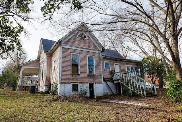 back of house featuring a yard and central air condition unit