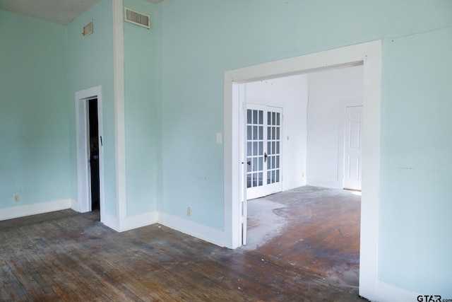 spare room with dark hardwood / wood-style flooring and french doors