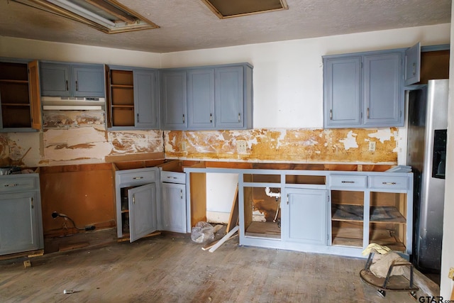 kitchen featuring stainless steel fridge with ice dispenser, a textured ceiling, and hardwood / wood-style floors