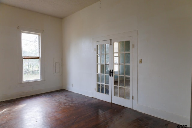 spare room featuring dark wood-type flooring and french doors