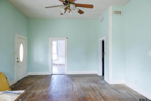 interior space with ceiling fan, dark wood-type flooring, a high ceiling, and a textured ceiling