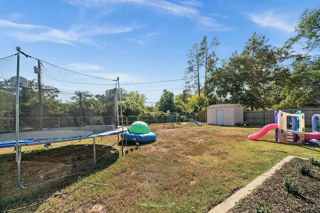 view of yard with a playground, a trampoline, and a storage unit