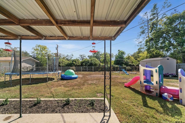 view of playground with a storage unit, a lawn, and a trampoline