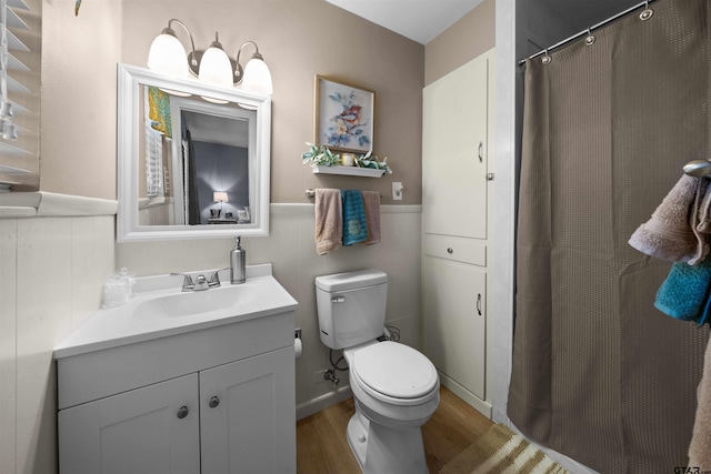 bathroom with toilet, vanity, and wood-type flooring