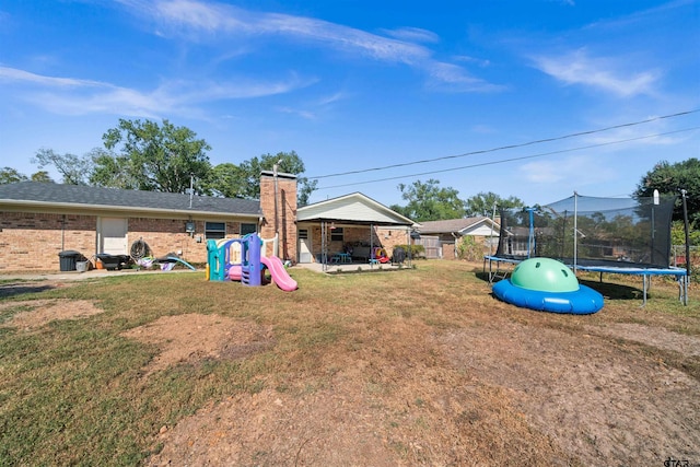 view of yard featuring a trampoline and a patio