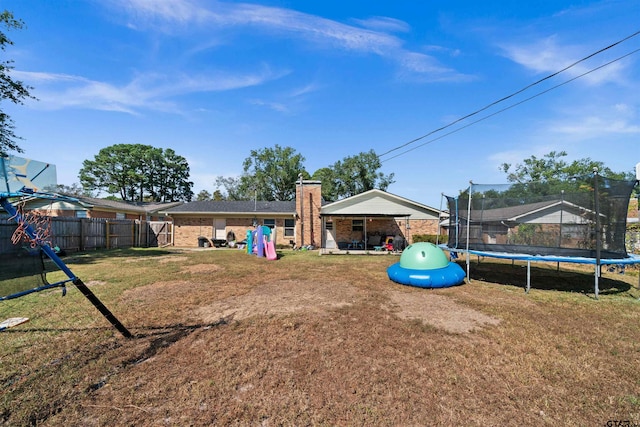 view of yard with a playground and a trampoline