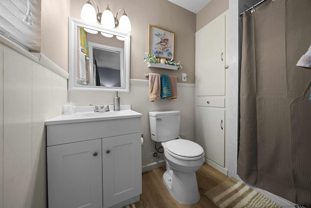 bathroom with toilet, vanity, and hardwood / wood-style floors