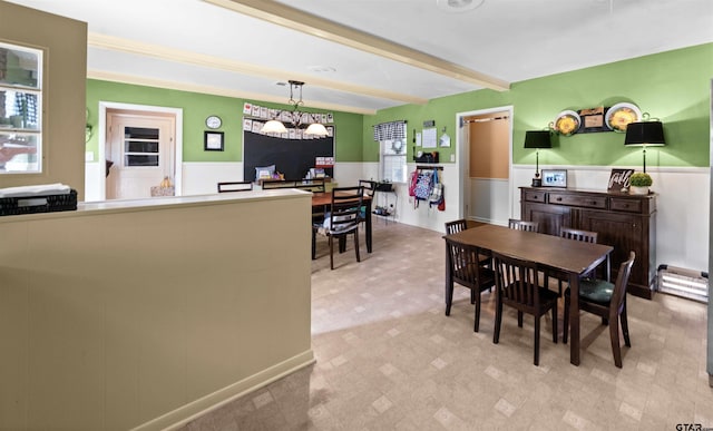 dining space with beamed ceiling and a notable chandelier