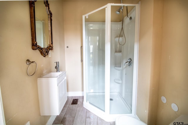 bathroom featuring a sink, visible vents, wood finished floors, and a shower stall