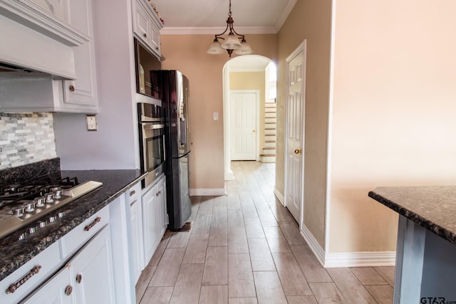 kitchen with wood finish floors, custom exhaust hood, arched walkways, appliances with stainless steel finishes, and tasteful backsplash