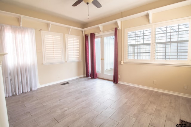 unfurnished room with visible vents, baseboards, a ceiling fan, and wood finished floors