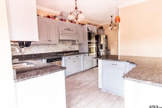 kitchen featuring ornamental molding, a sink, decorative light fixtures, appliances with stainless steel finishes, and decorative backsplash