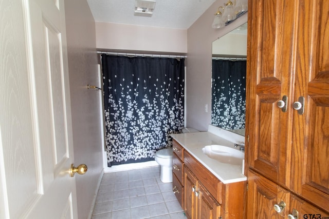 full bathroom featuring tile patterned floors, a shower with curtain, toilet, a textured ceiling, and vanity