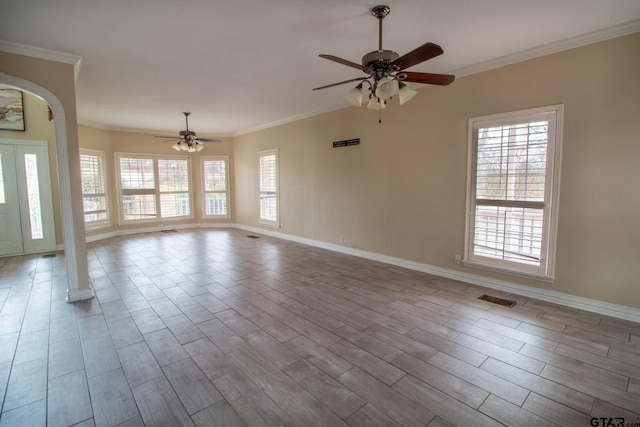 unfurnished living room with visible vents, crown molding, baseboards, wood finished floors, and a ceiling fan