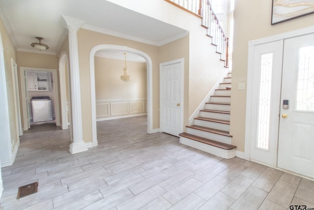 foyer entrance featuring stairs, visible vents, wood tiled floor, and crown molding