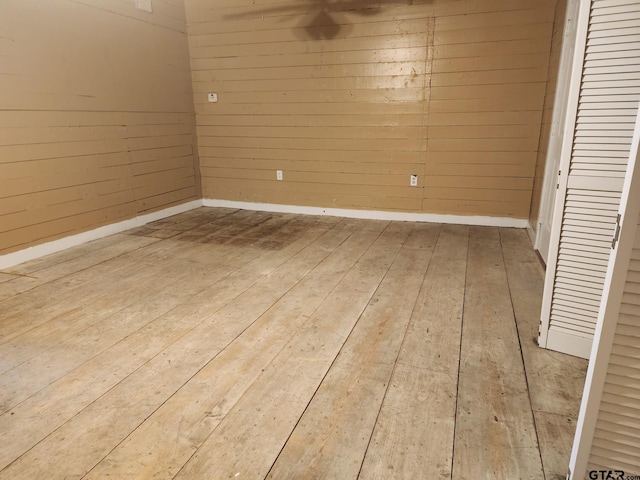 interior space with wood-type flooring and wooden walls