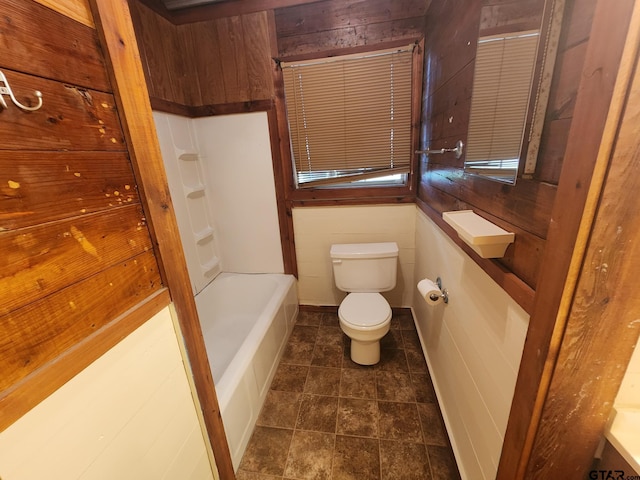 bathroom featuring wooden walls and toilet