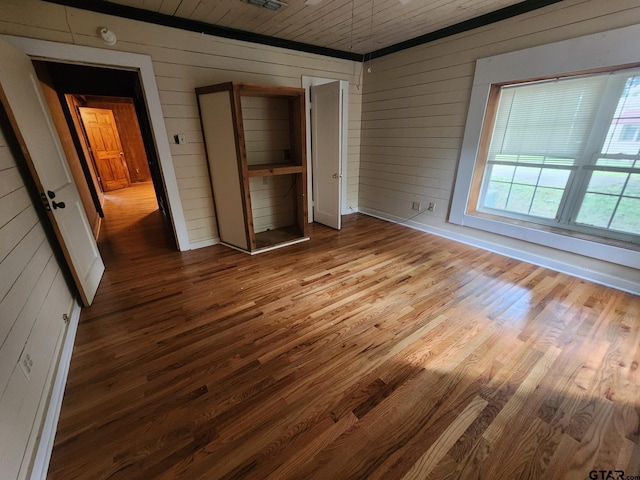 unfurnished bedroom featuring wood ceiling, light hardwood / wood-style flooring, and wood walls