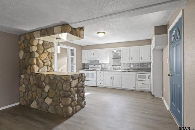 kitchen featuring a sink, white appliances, light wood finished floors, white cabinets, and under cabinet range hood