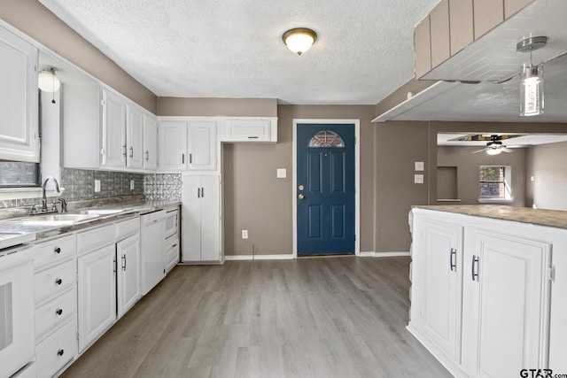 kitchen featuring white cabinets, a textured ceiling, baseboards, light wood-style floors, and a ceiling fan