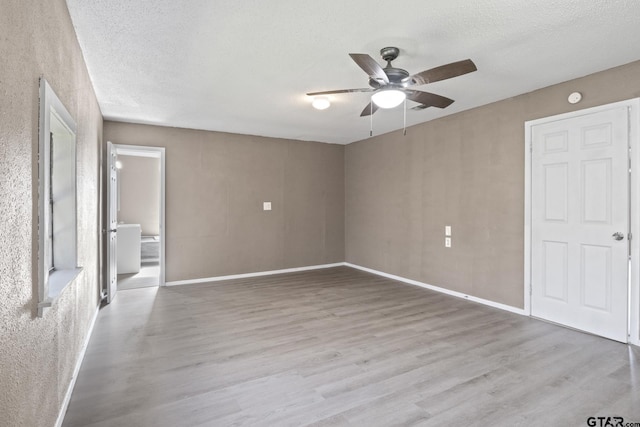 unfurnished bedroom with wood finished floors, a textured ceiling, ceiling fan, and connected bathroom