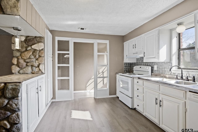 kitchen with visible vents, a sink, white appliances, light wood-type flooring, and a textured ceiling
