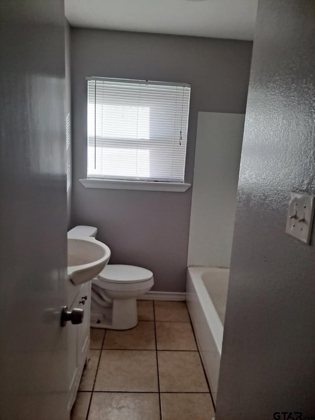 3107 Hamilton Ln, Texarkana, TX 75501 - bathroom with toilet, tile patterned flooring, a tub, baseboards, and a sink
