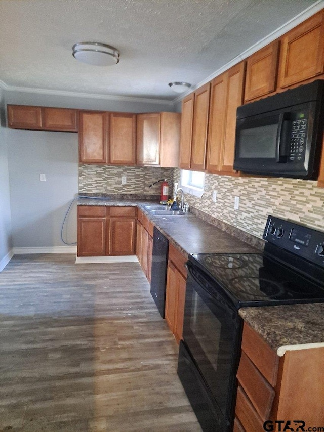 3107 Hamilton Ln, Texarkana, TX 75501 - kitchen with black appliances, a sink, dark wood-style floors, brown cabinetry, and dark countertops