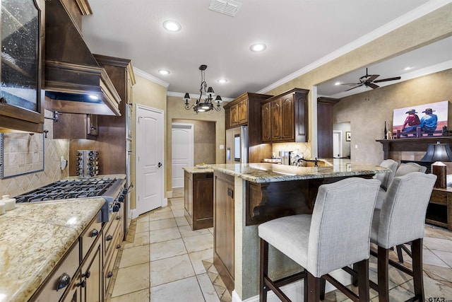 11187 Hunters Trl, Flint, TX 75762 - kitchen with custom range hood, stainless steel appliances, ornamental molding, tasteful backsplash, and a kitchen bar