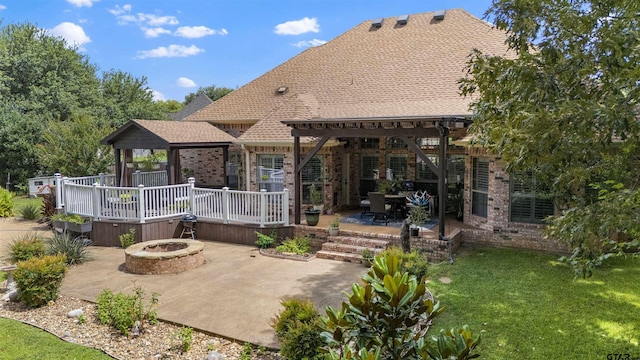 11187 Hunters Trl, Flint, TX 75762 - back of house with an outdoor fire pit, brick siding, a wooden deck, a patio area, and a yard