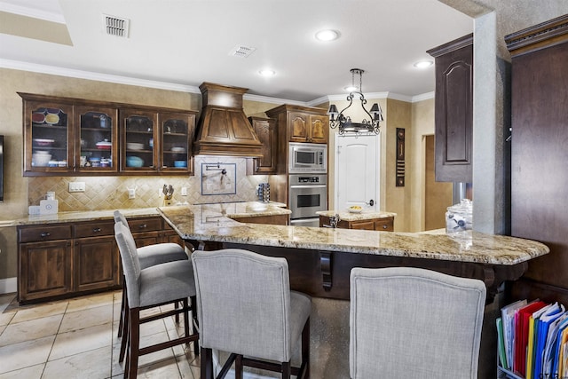 11187 Hunters Trl, Flint, TX 75762 - kitchen with appliances with stainless steel finishes, custom range hood, a kitchen island, decorative backsplash, and glass insert cabinets