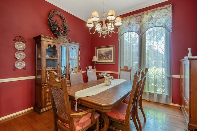 dining space featuring crown molding, an inviting chandelier, and hardwood / wood-style flooring