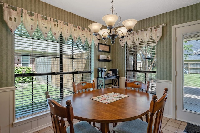 dining space with light tile patterned floors and an inviting chandelier