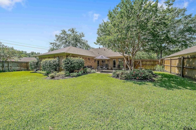 back of house with a patio area and a yard