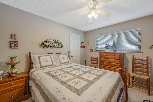 carpeted bedroom with ceiling fan and a textured ceiling