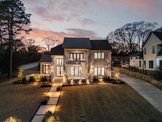 modern farmhouse featuring stone siding and a balcony