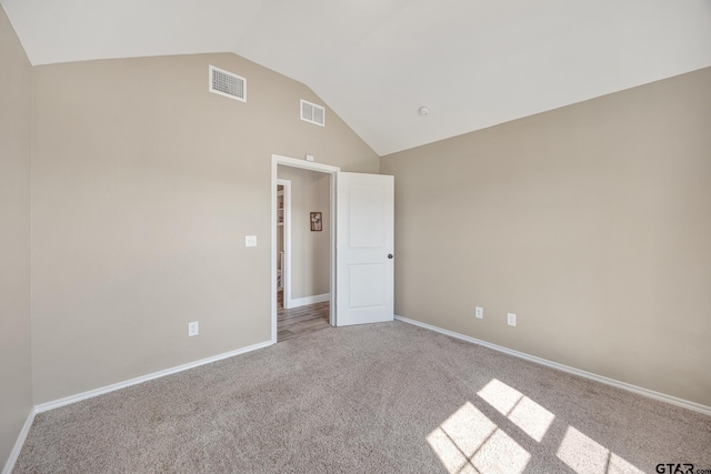 unfurnished room featuring vaulted ceiling and light carpet