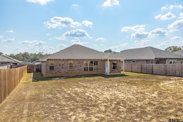 rear view of property with a patio and a yard