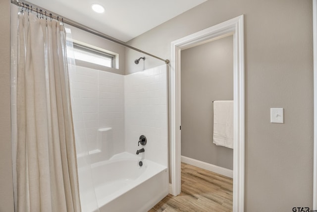 bathroom with hardwood / wood-style floors and shower / bathtub combination with curtain